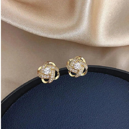 Pendientes dorados con forma de espiral floral y cristales